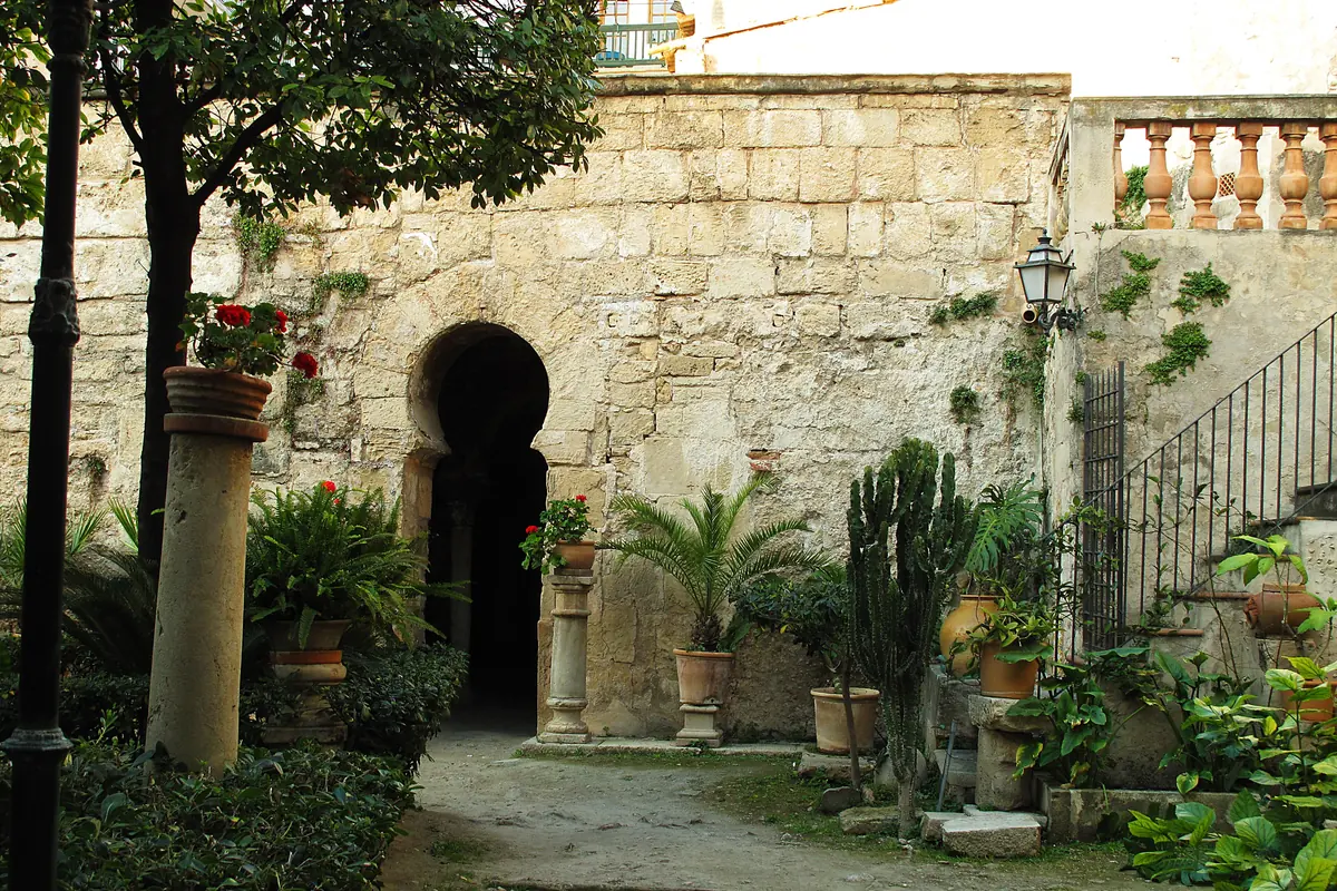A horseshoe-arched doorway and garden at the Arab Baths in Palma